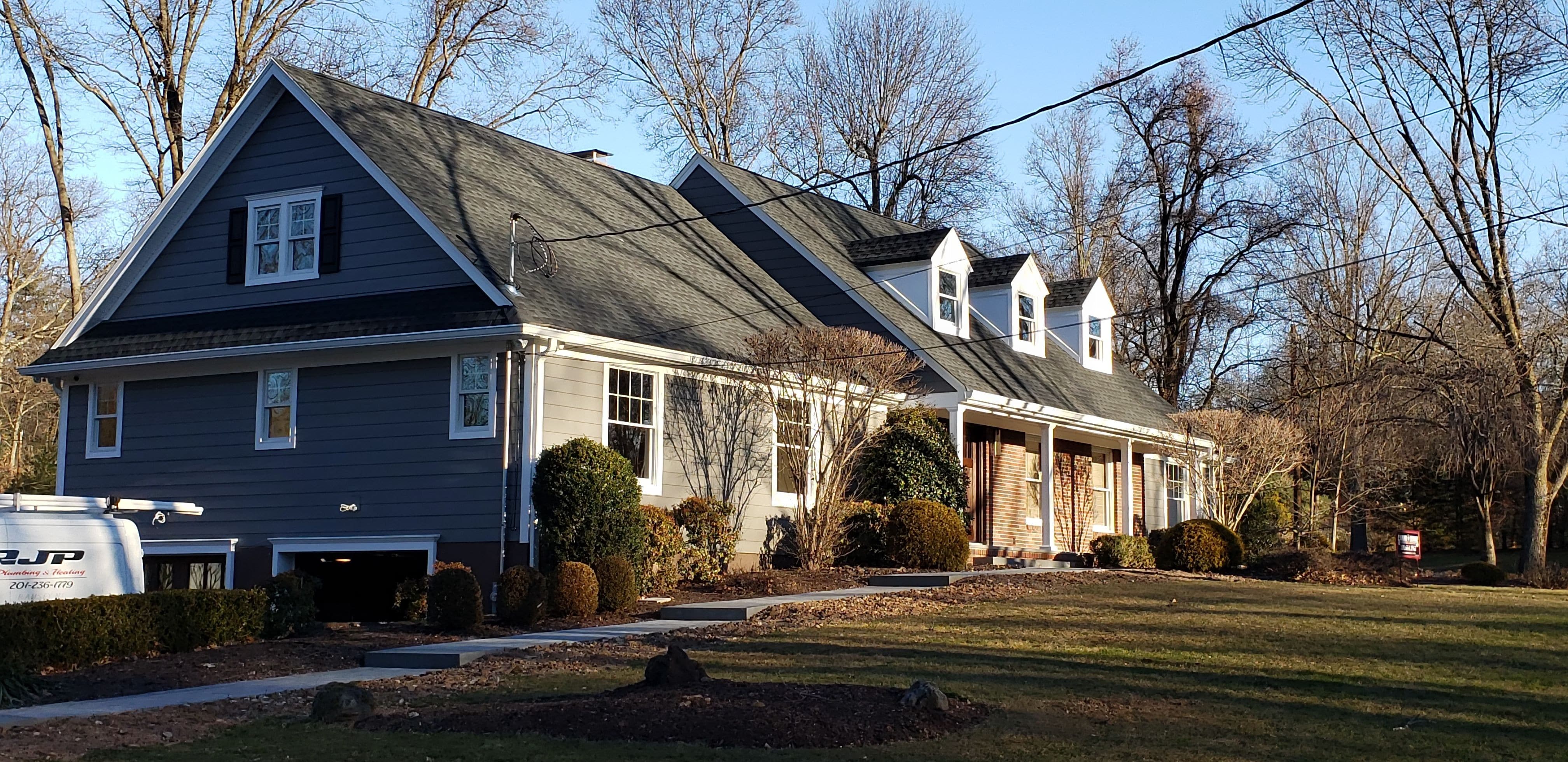 With new azek panel dormers, gray hardie-plank siding, and charcoal shingle roof the new details of this home stand out as the finest on the block